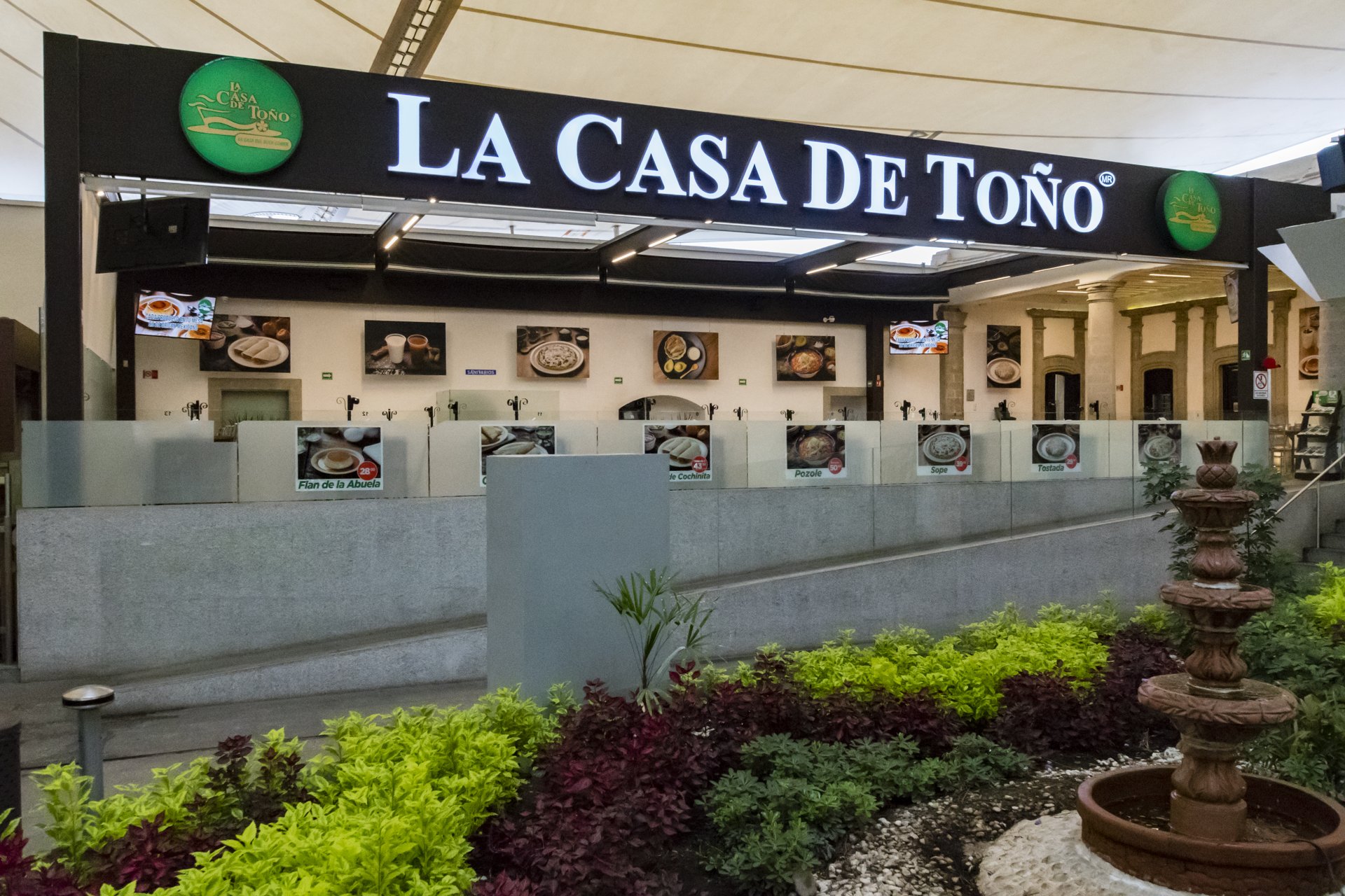 Sucursal de La Casa de Toño en plaza comercial con jardín y fuente